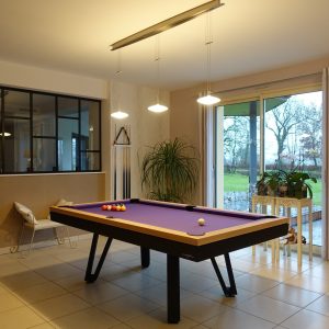 Salle de billard design noir et chêne naturel devant cuisine avec verrière